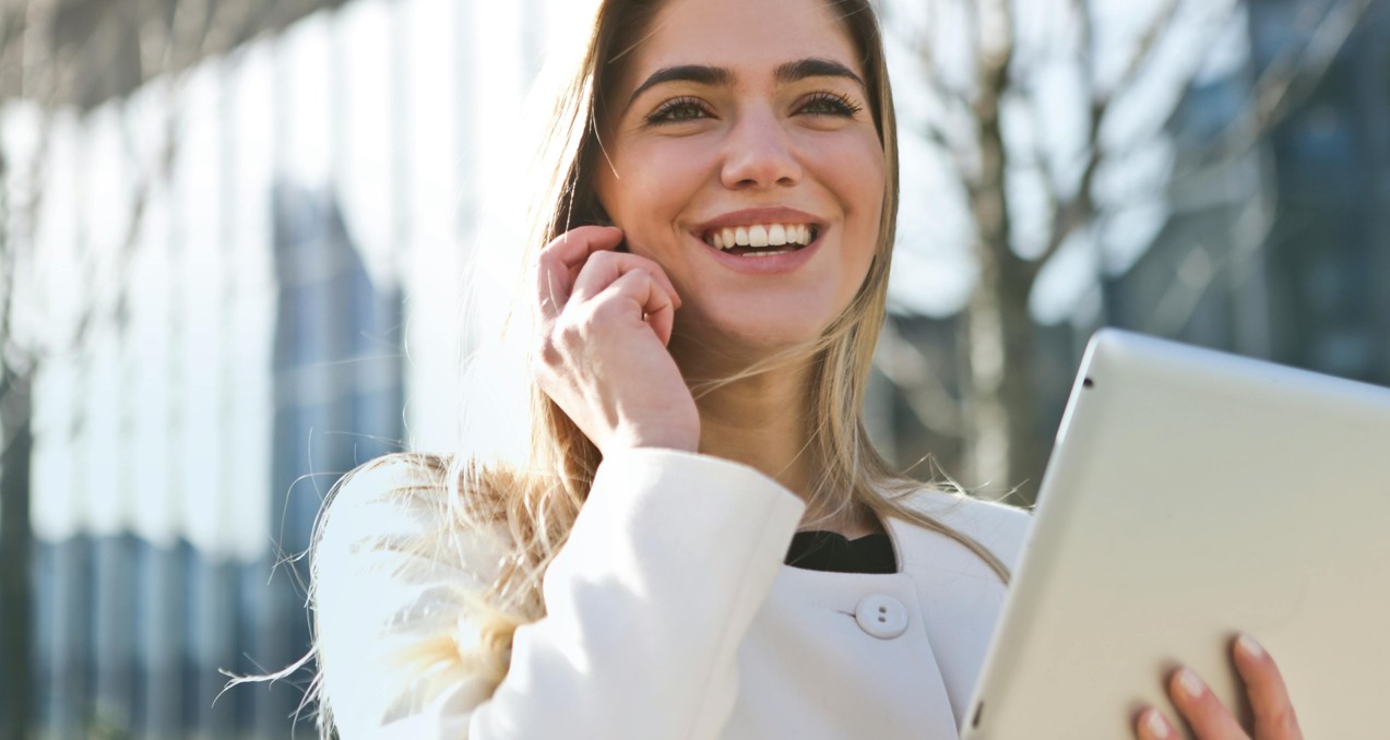 Woman smiling while checking her EuroMillions online account on a tablet